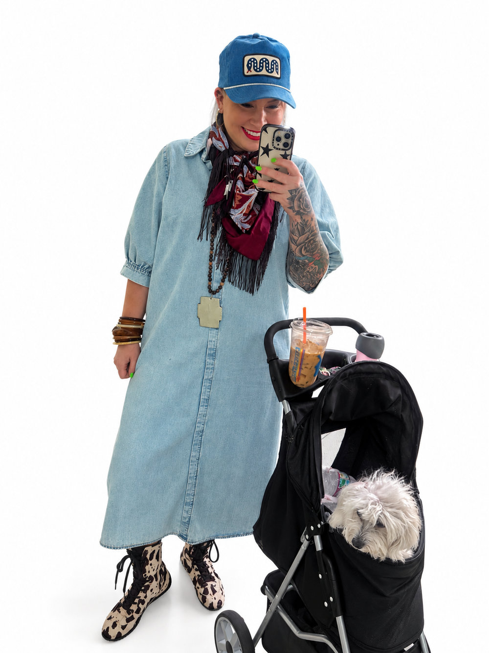 Jennifer wearing a denim maxi dress and printed boots beside her dog stroller